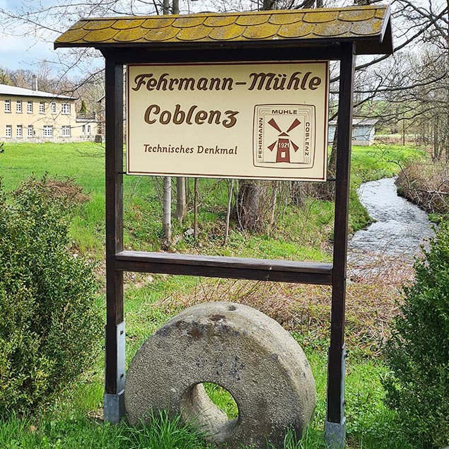 Schild und Mühlstein an der Fehrmann-Mühle Coblenz