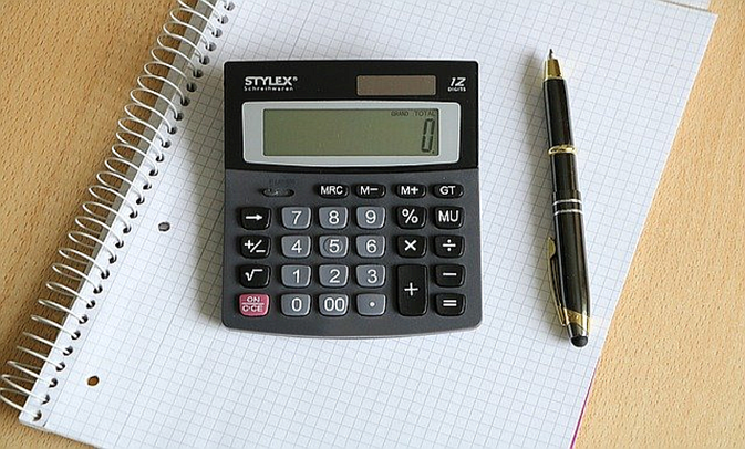 Taschenrechner und Stift auf kariertem Block