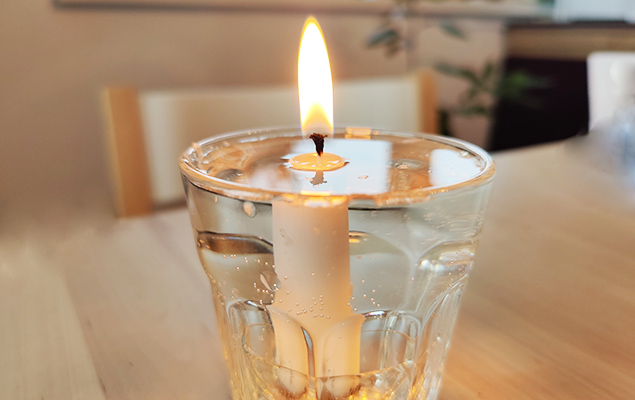 brennende Kerze in Wasserglas
